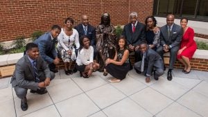 Ten of John Thompson's family members sit next to him outside of the building named after him.