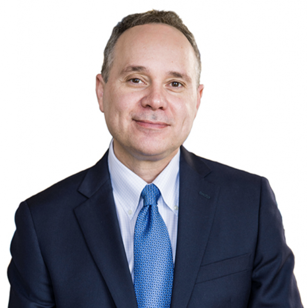 Eddie Maloney wearing a blue suit and tie with white background