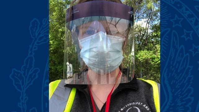 Suzie Stephenson wears a protective face mask and shield.