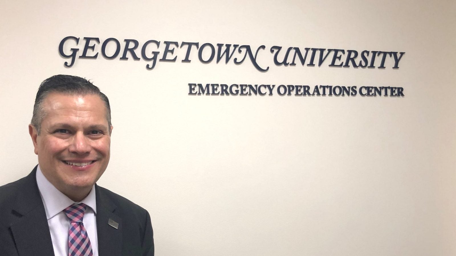 Marc Barbiere stands in front of Georgetown University Emergency Operations Center sign