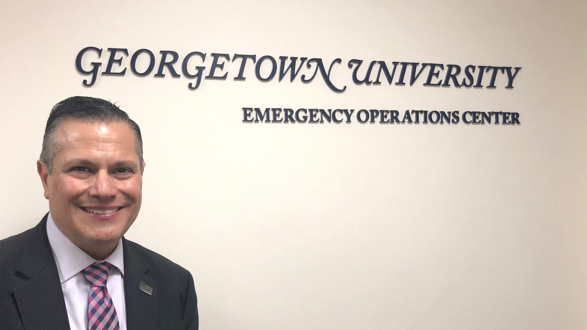 Marc Barbiere stands in front of Georgetown University Emergency Operations Center sign