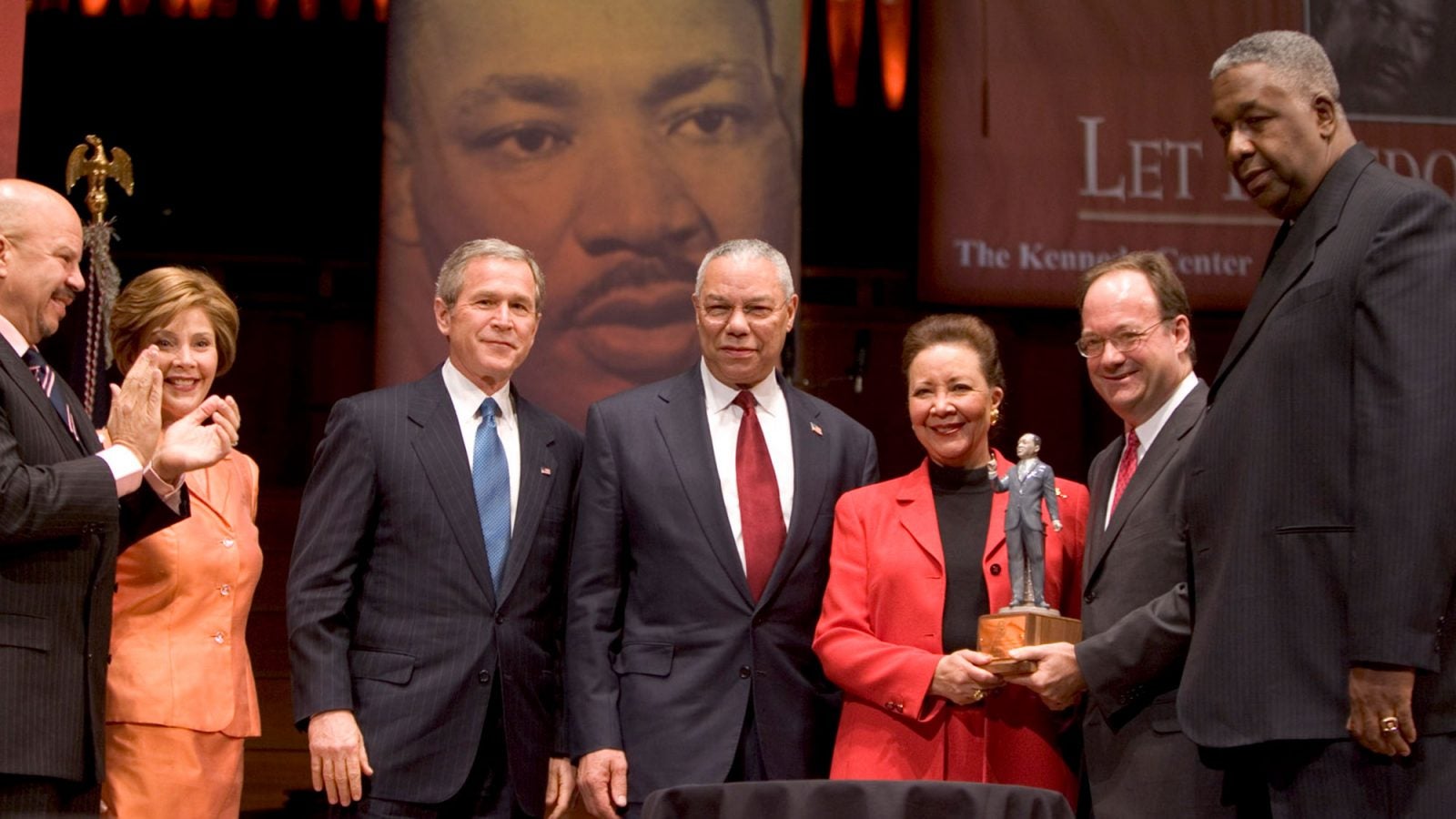 Tom Joyner, Laura Bush, George W. Bush and Colin Powell stand to the left of Alma Powell who is receiving an award from John J. DeGioia standing to her right with John Thompson Jr.