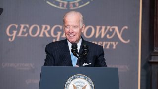 President Joe Biden speaks from a podium with a Georgetown University sign behind him