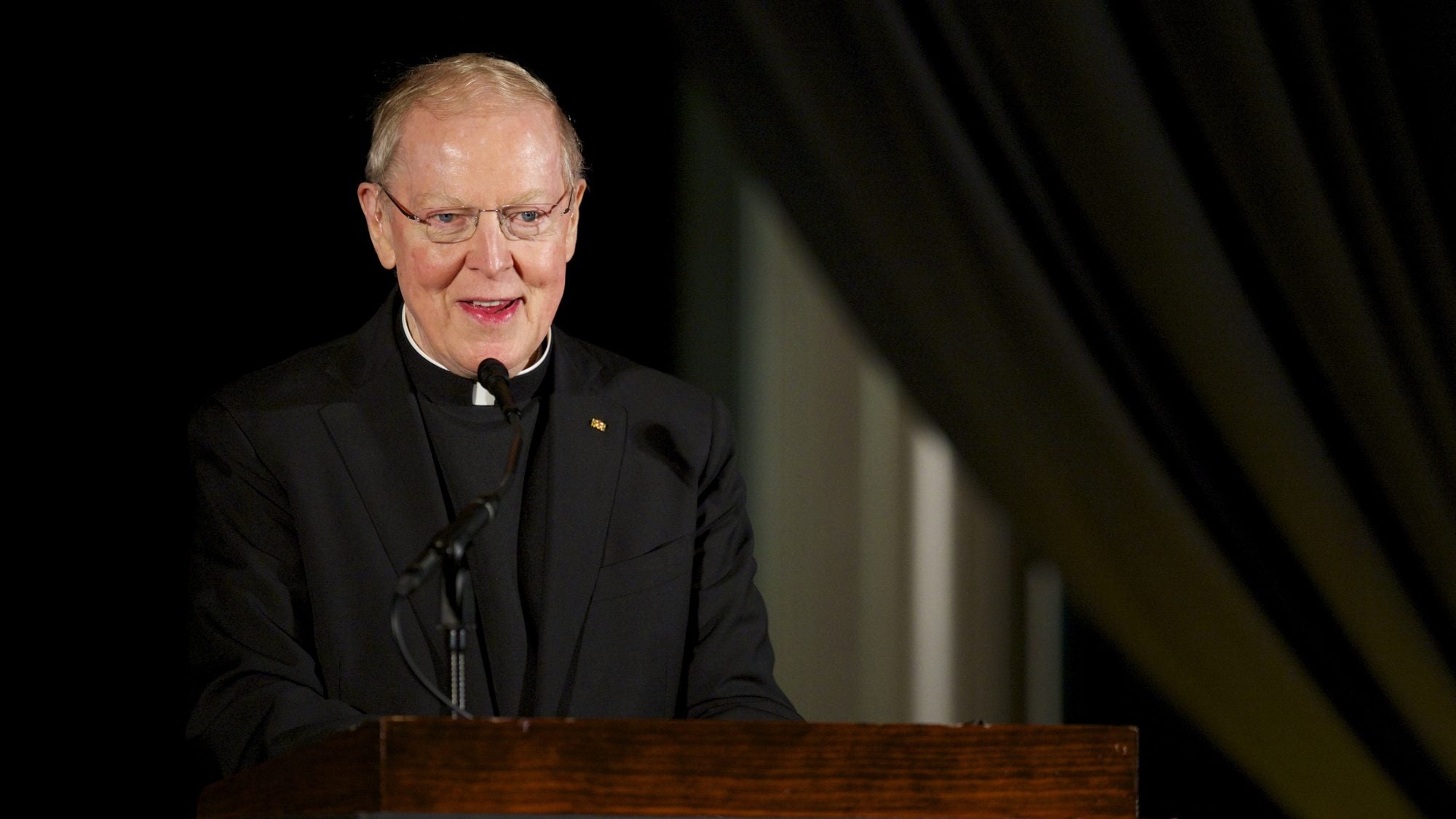 Father Leo J. O&#039;Donovan speaks at a podiium