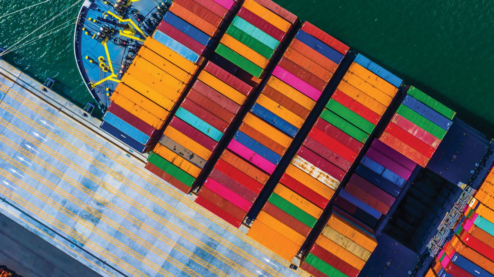 An aerial view of a cargo ship carrying colorful shipping containers