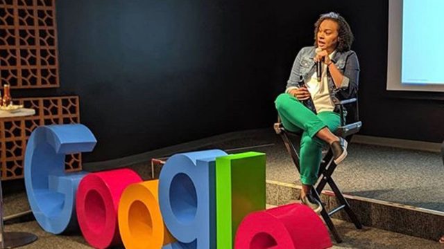 Cherizza Lundy sits in a chair on stage with a microphone in her hand and the Google logo in front of her.