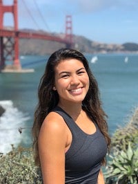 Nikki Feenstra posing outdoors in San Francisco in front of the Golden Gate Bridge and water