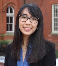 Sonya Hu in an outdoor photo standing in Dahlgren Quadrangle in front of Healy Hall and Maguire Hall