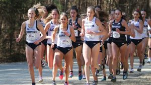 The Cross country women's team runs during competition.