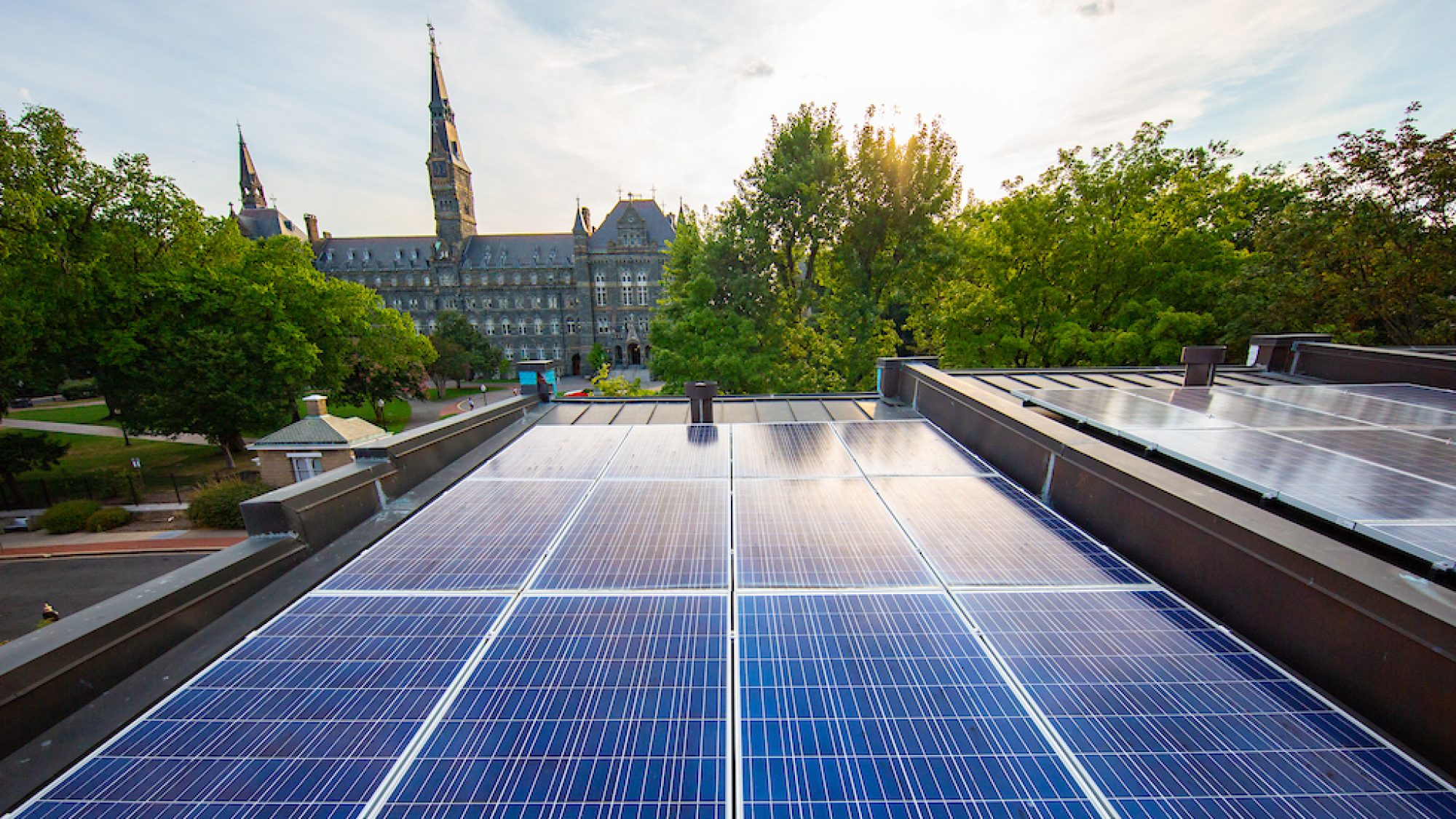 Solar panels on Georgetown townhouse rooftops with Healy Hall in the background