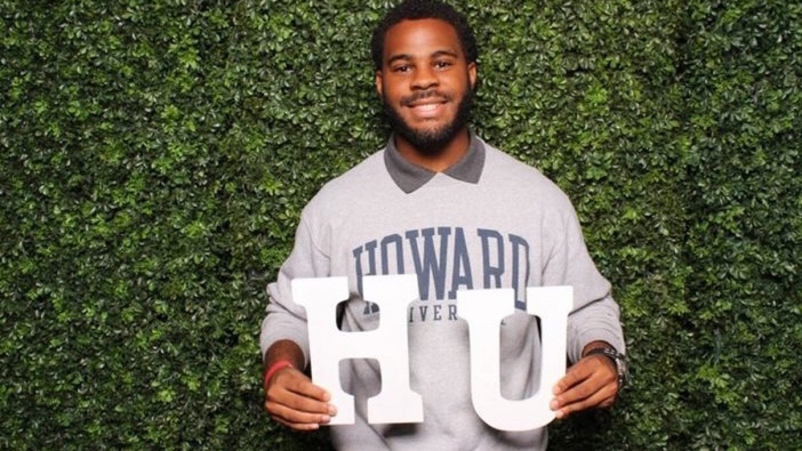 Quentin Byrd wears a Howard sweatshirt and holds &quot;HU&quot; letters