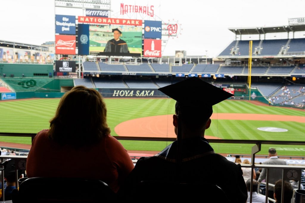 A graduating student and their guest look at Nats Park