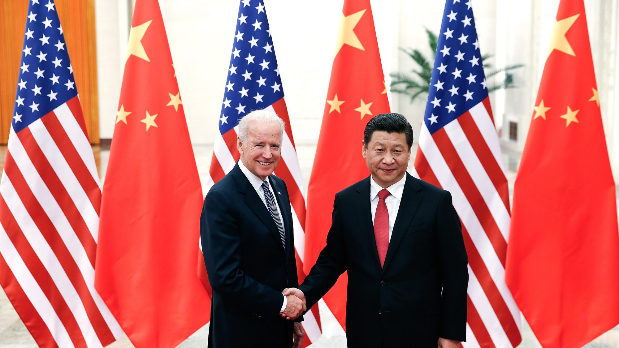 Xi and Biden shake hands in front of Chinese and American flags