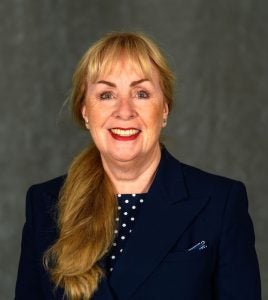 Headshot of Clare Sullivan wearing a polka dot blouse and dark blazer