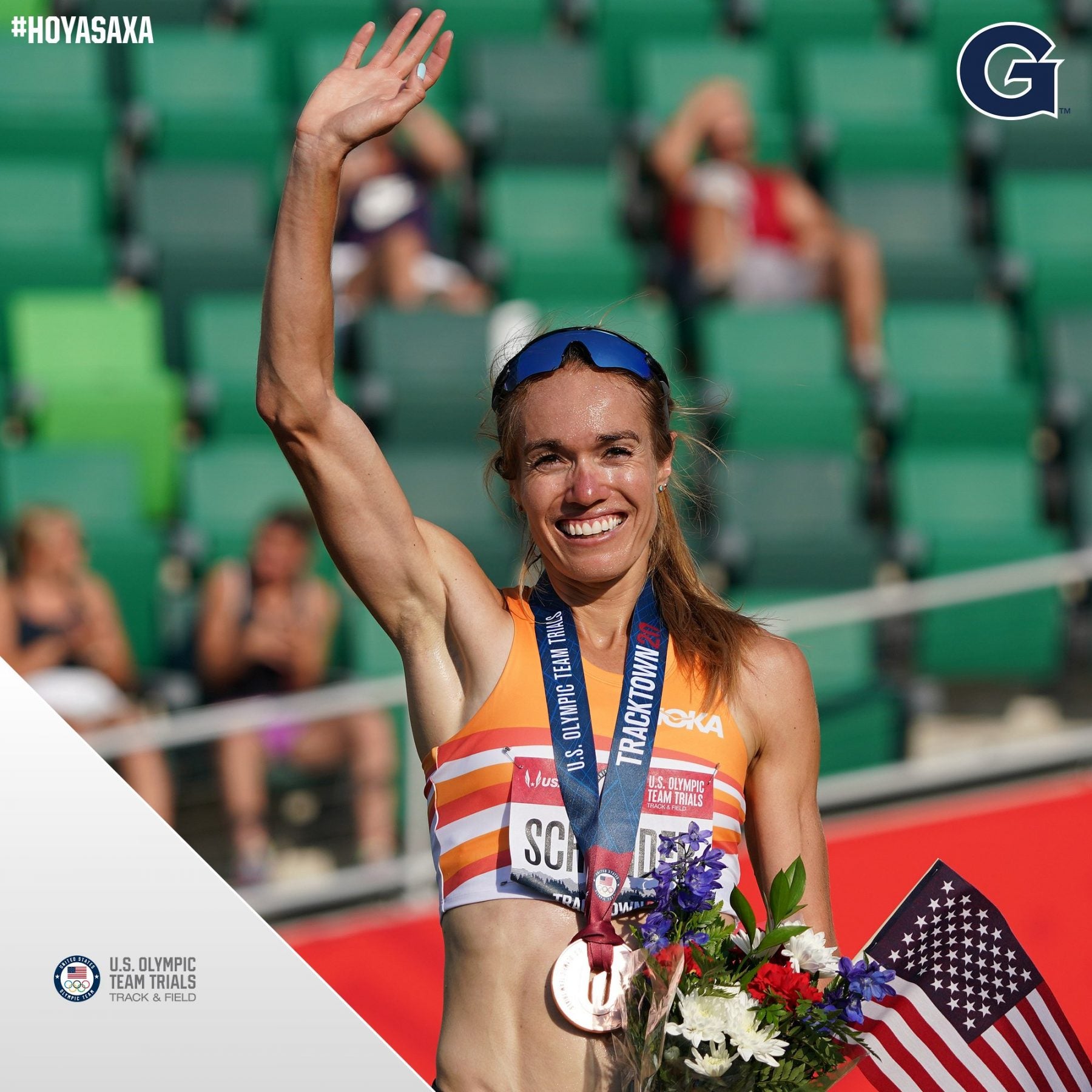 Rachel Schneider waves while wearing a medal