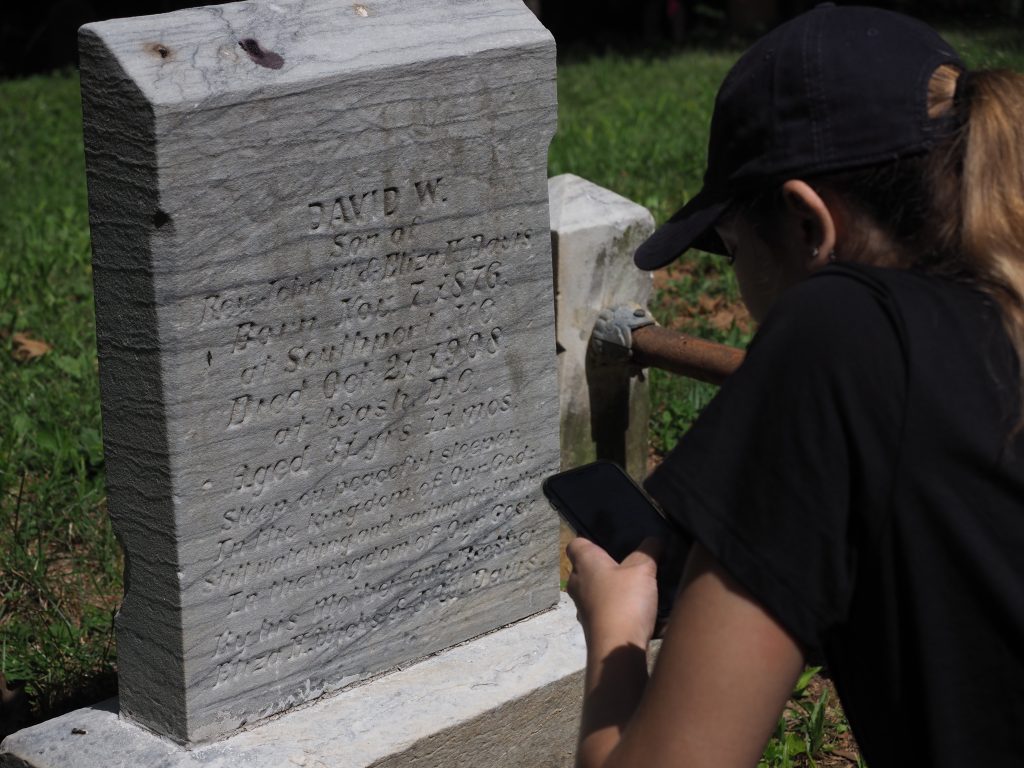 Student logs a headstone inscription on her phone