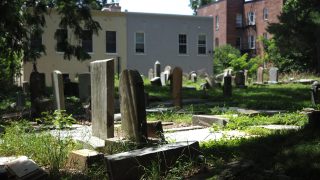 Gravestones with Georgetown neighborhood buildings in the background