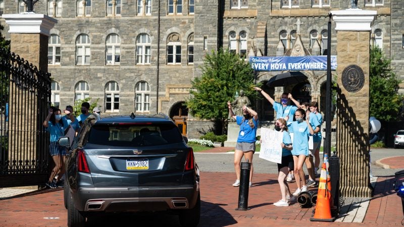 Orientation Advisors cheer as a car drives through the front gates