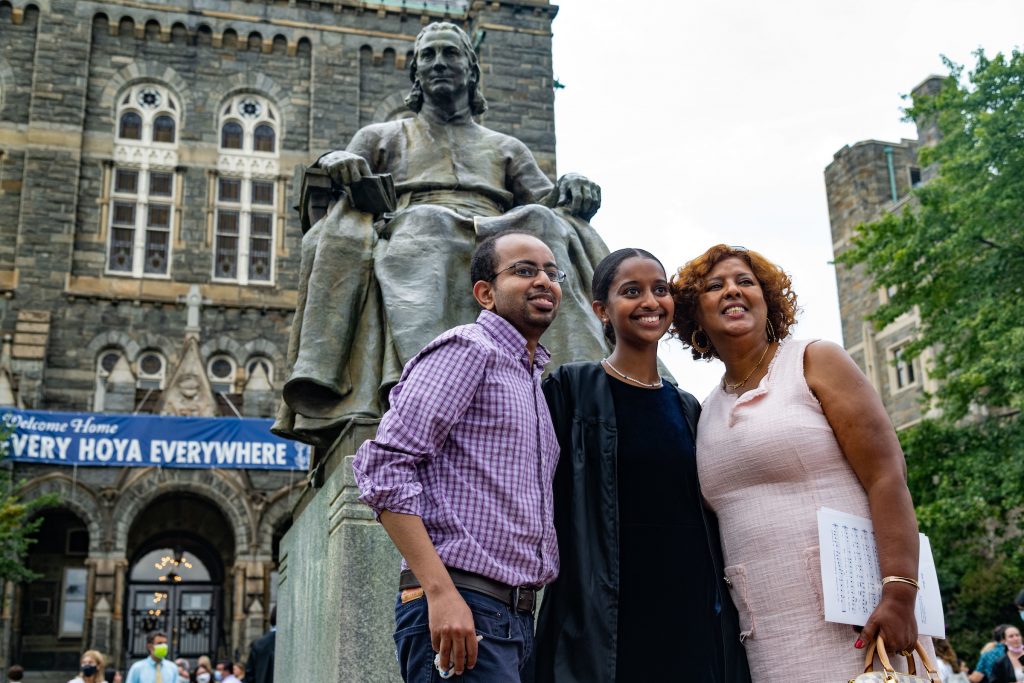 Family poses in front of John Carroll statue