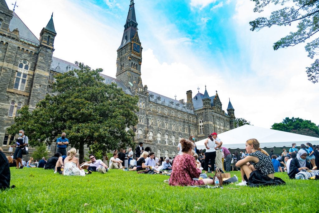 Students sit on Healy lawn in small groups