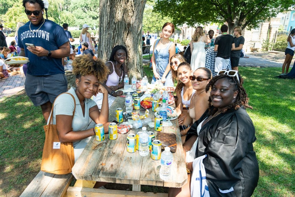 Students eat around a picnic bench