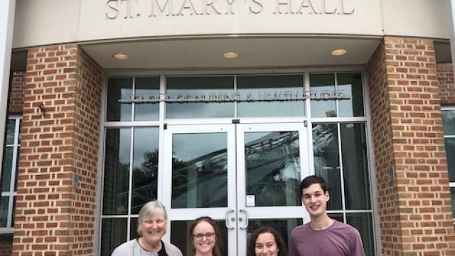 Leaders of the CURA pre-orientation program stand in front of St. Mary&#039;s Hall