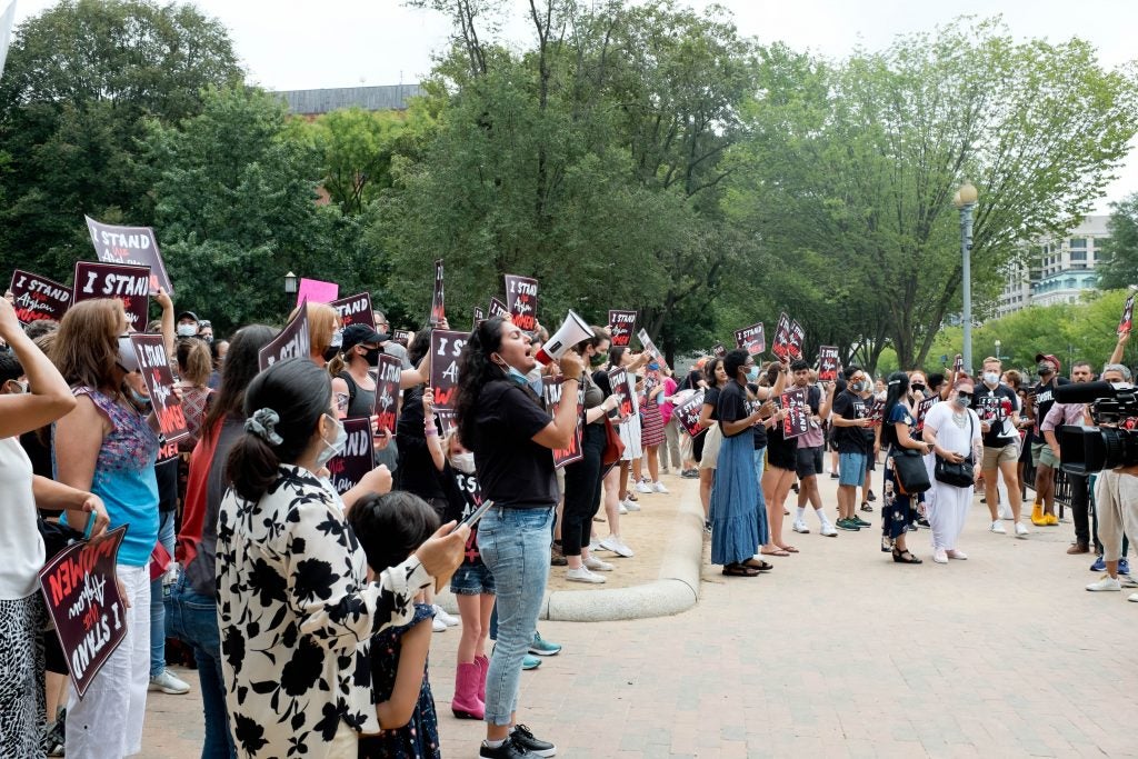 Protester in a crowd yells into a megaphone