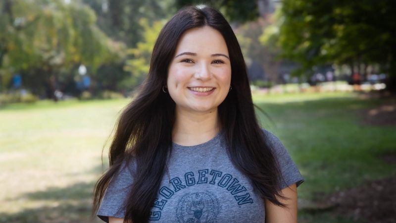 Bayley Wivell wearing a gray Georgetown T-shirt outside in front of an open grass area