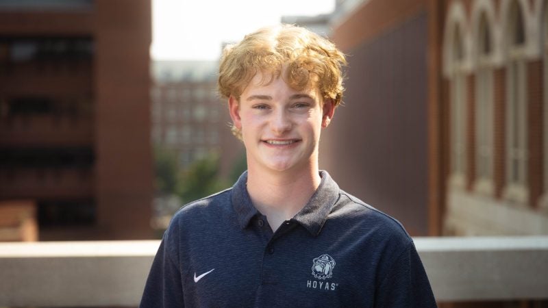 Will Stockdale wearing a dark blue Georgetown polo shirt on Leavey Bridge