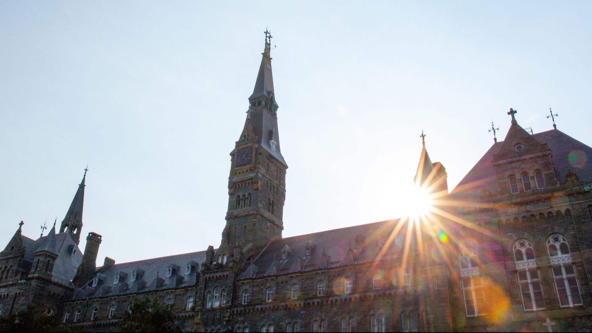 Sun shining behind Healy Hall at sunset