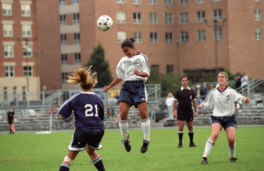 Soccer player bounces a soccer ball off her head