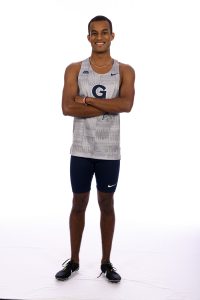 Maazin Ahmed wears a gray Georgetown jersey and stands with his arms folded