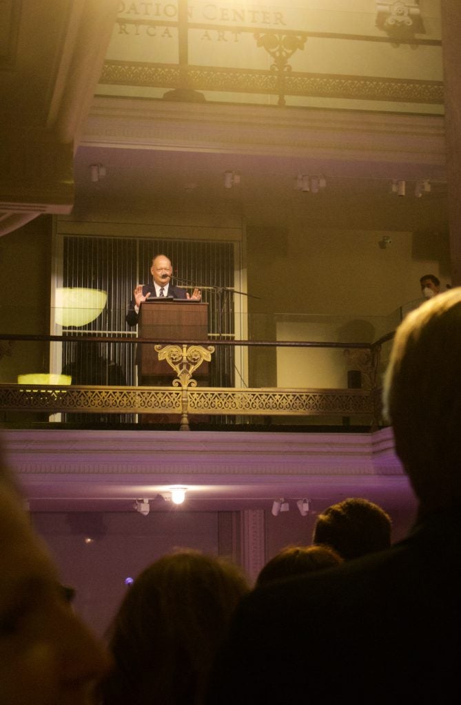 President DeGioia speaks from a podium a level above the audience