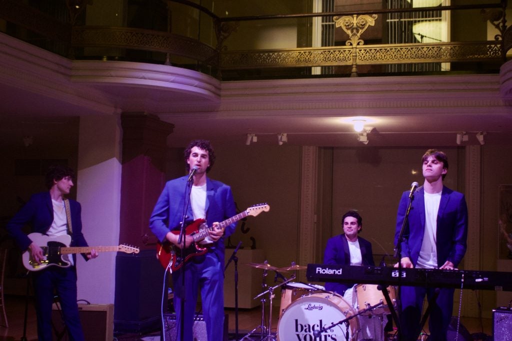 A band plays under purple light