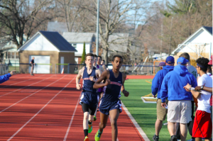 Young Maazin Ahmed runs on a track in front of other competitors