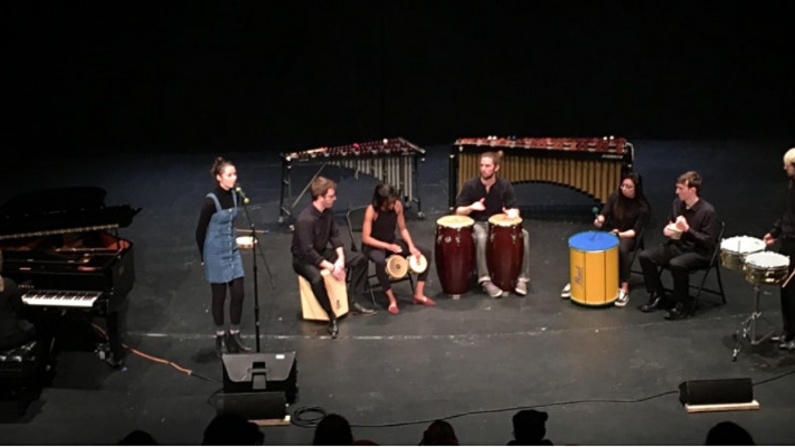 A group of students on stage with various musical instruments.