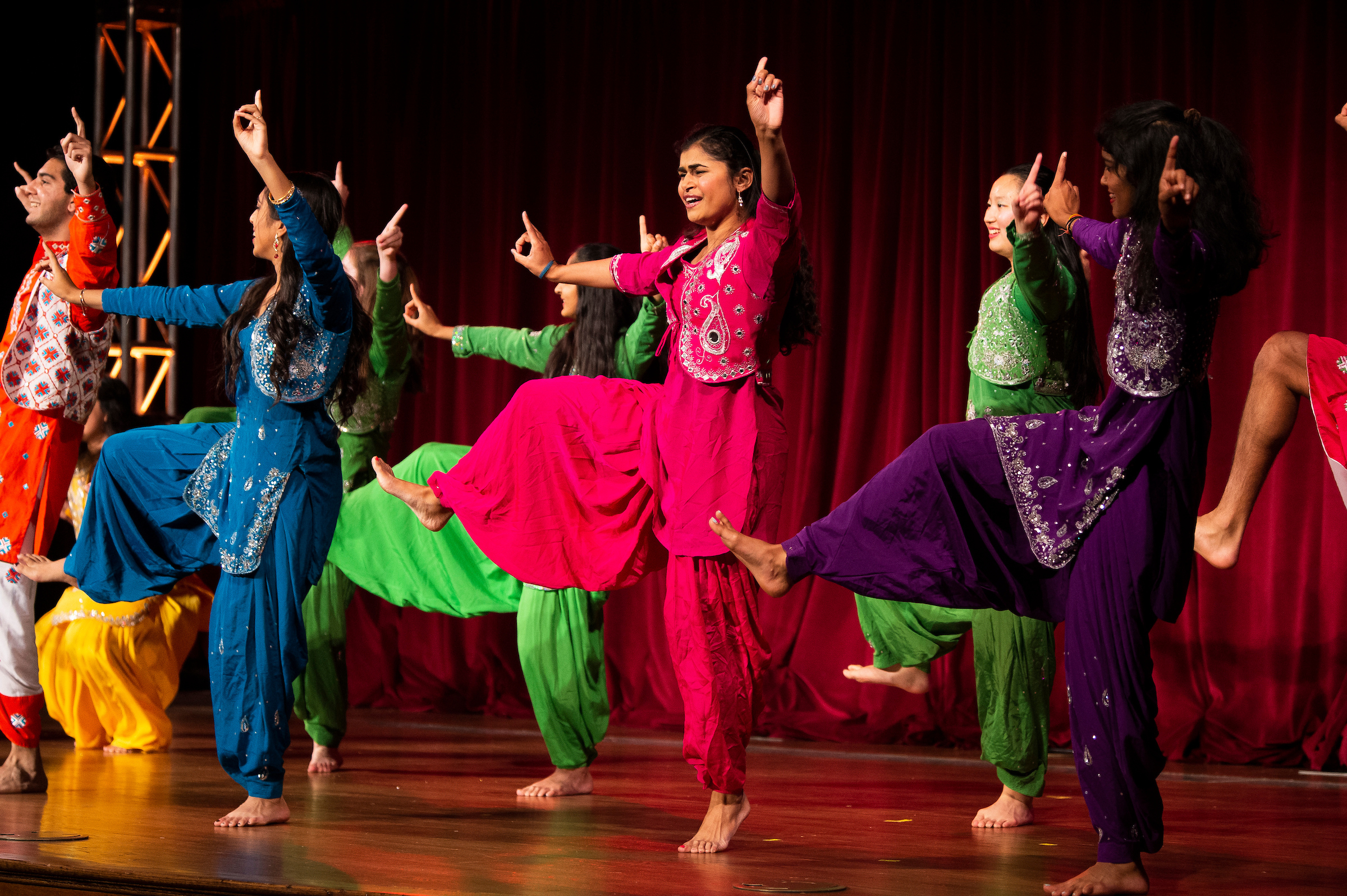 Students in colorful outfits perform in a South Asian dance showcase