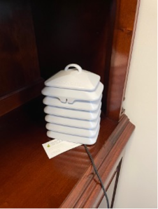 Small, white, accordion-like device on a wood dresser