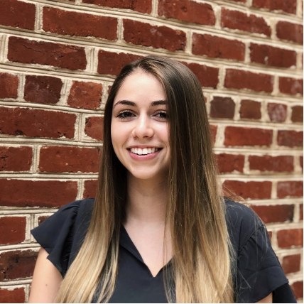 Anna Giaquinto stands in front of a brick wall