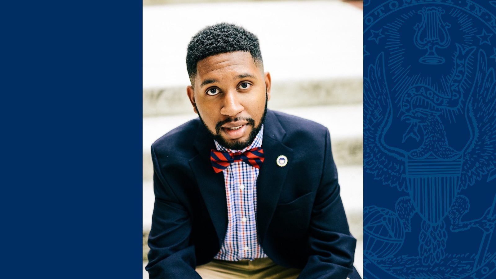 Rev. TauVaughn Toney wears a bowtie and blazer in a headshot on a blue background