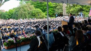 Graduates in the audience as President DeGioia speaks in front of faculty