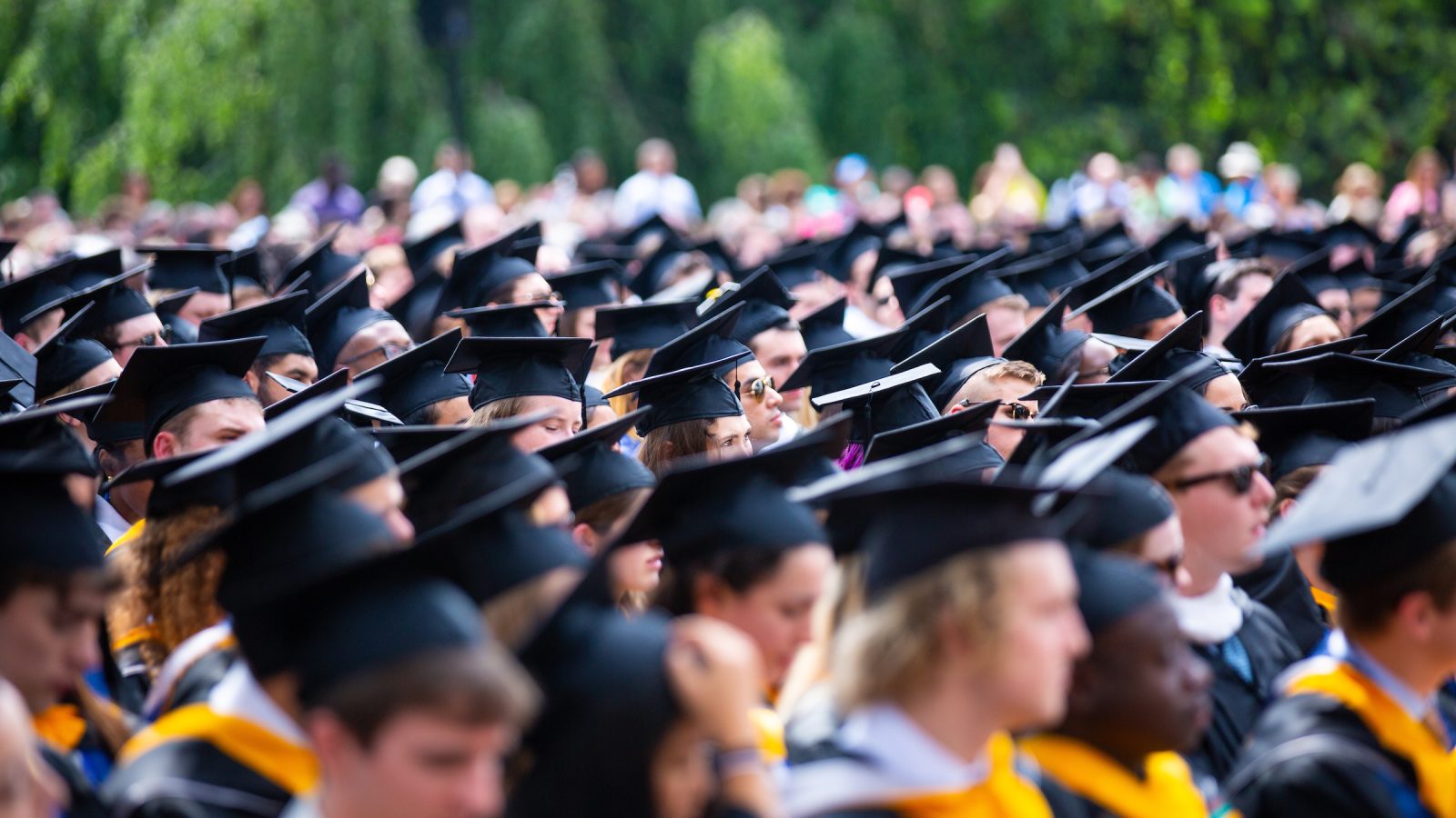 A crowd of students wearing graduation caps and gowns