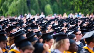 A crowd of students wearing graduation caps and gowns