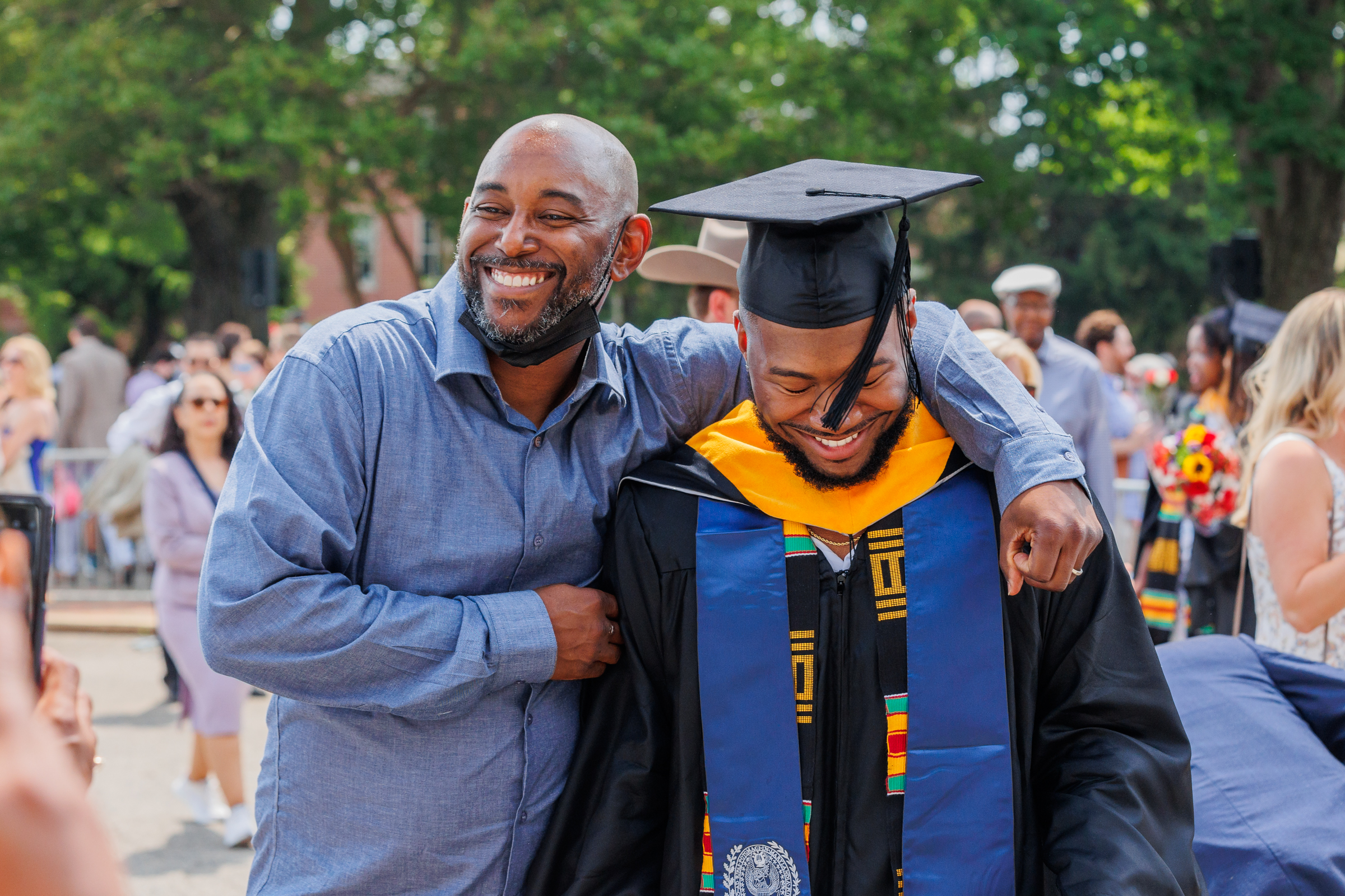 A man puts his arm around a graduate