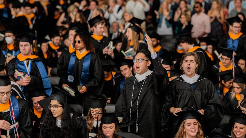 Students wear graduation attire and celebrate