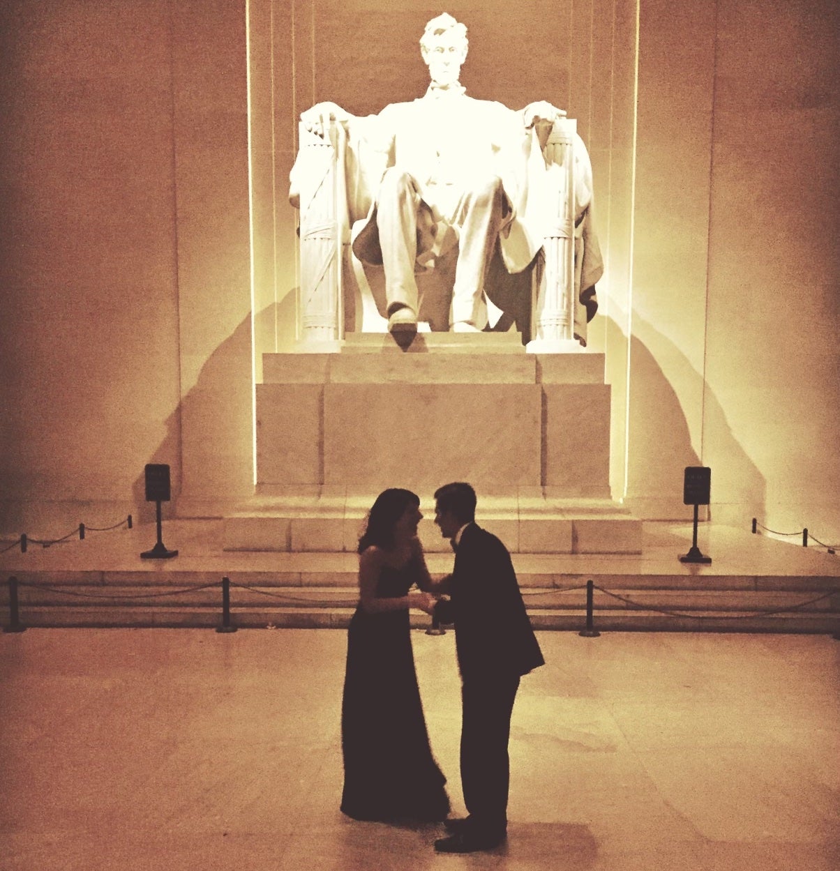 Two people in formal clothes in front of the Lincoln Memorial
