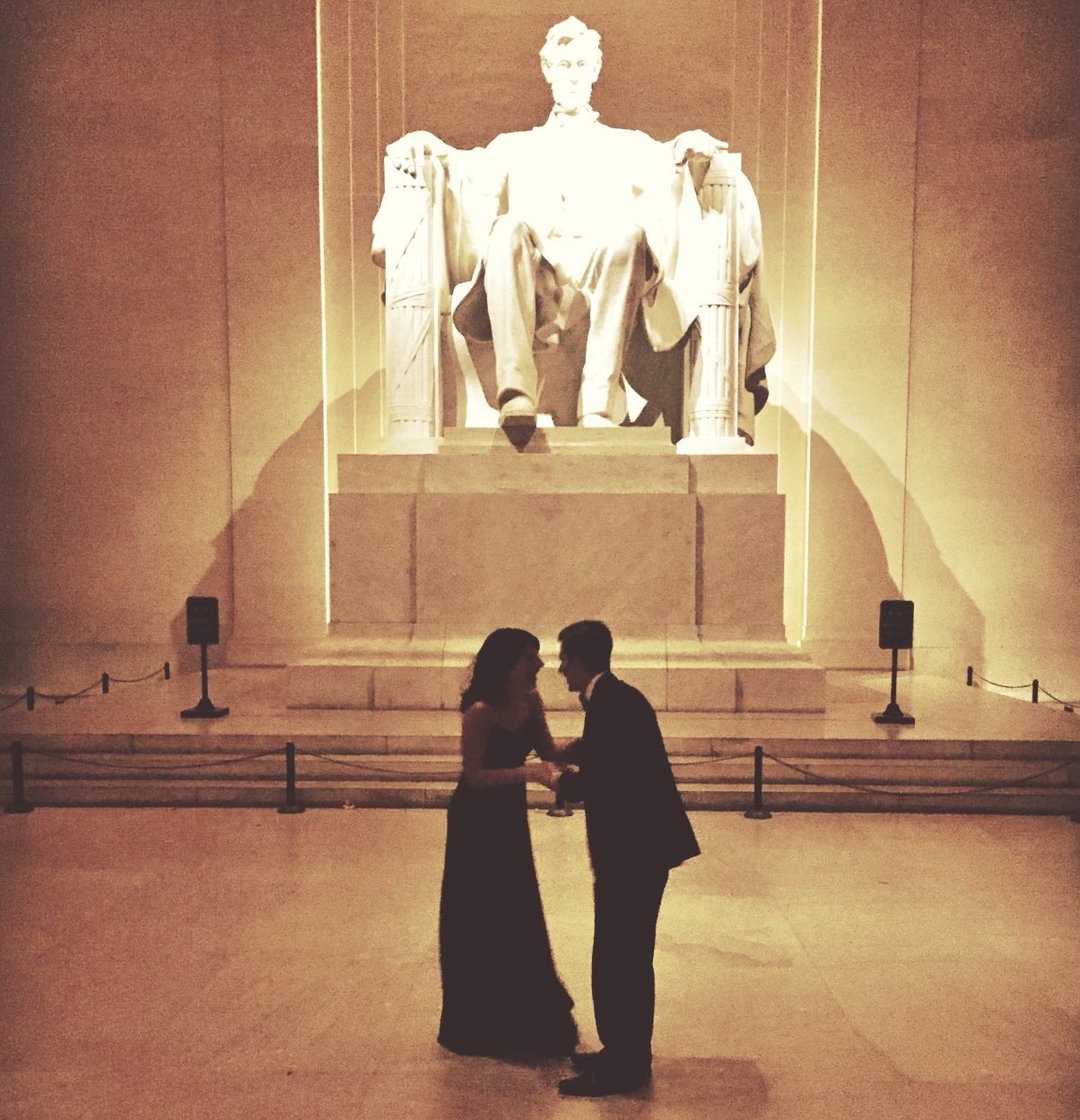 Two people in formal clothes in front of the Lincoln Memorial