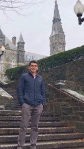 Abel Cruz Flores stands on steps with Healy Hall in the background