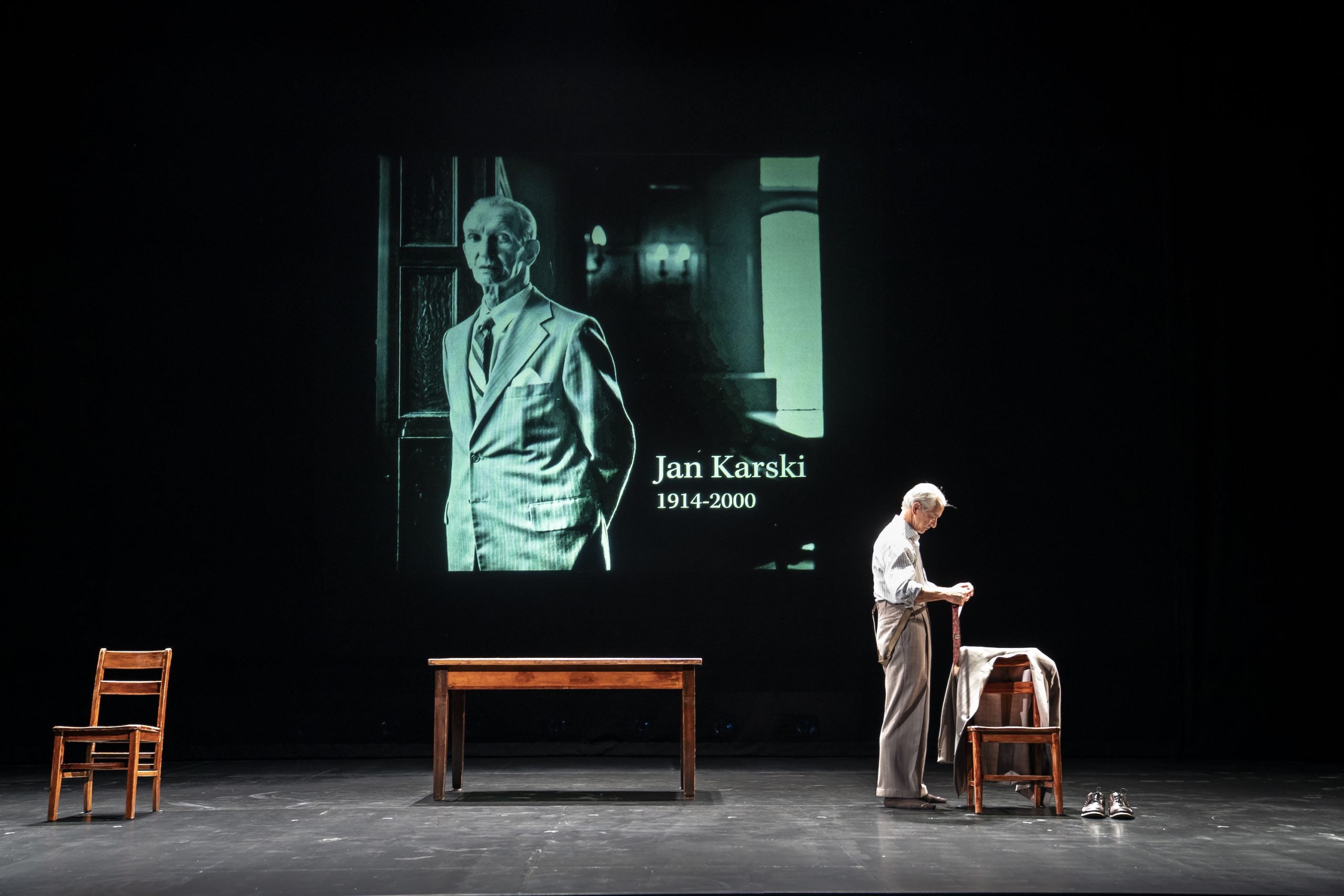 Strathairn as Karski stands in front of a projection of the real Jan Karski