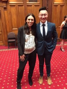 Charlie Wang stands with the prime minister of New Zealand during an awards ceremony in May 2018.